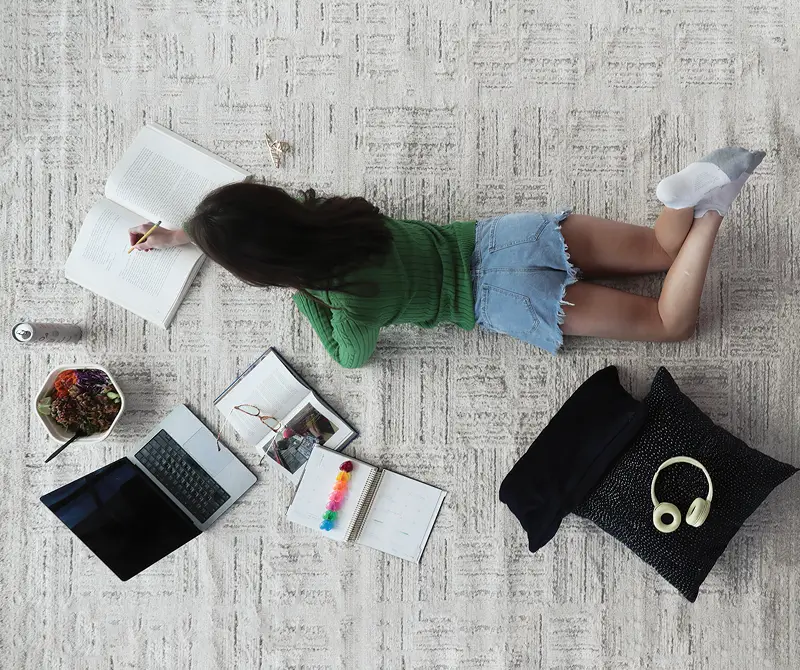 Girl laying on floor writing in a notebook